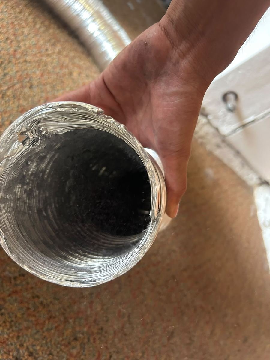 Technician holding a cleaned dryer vent hose